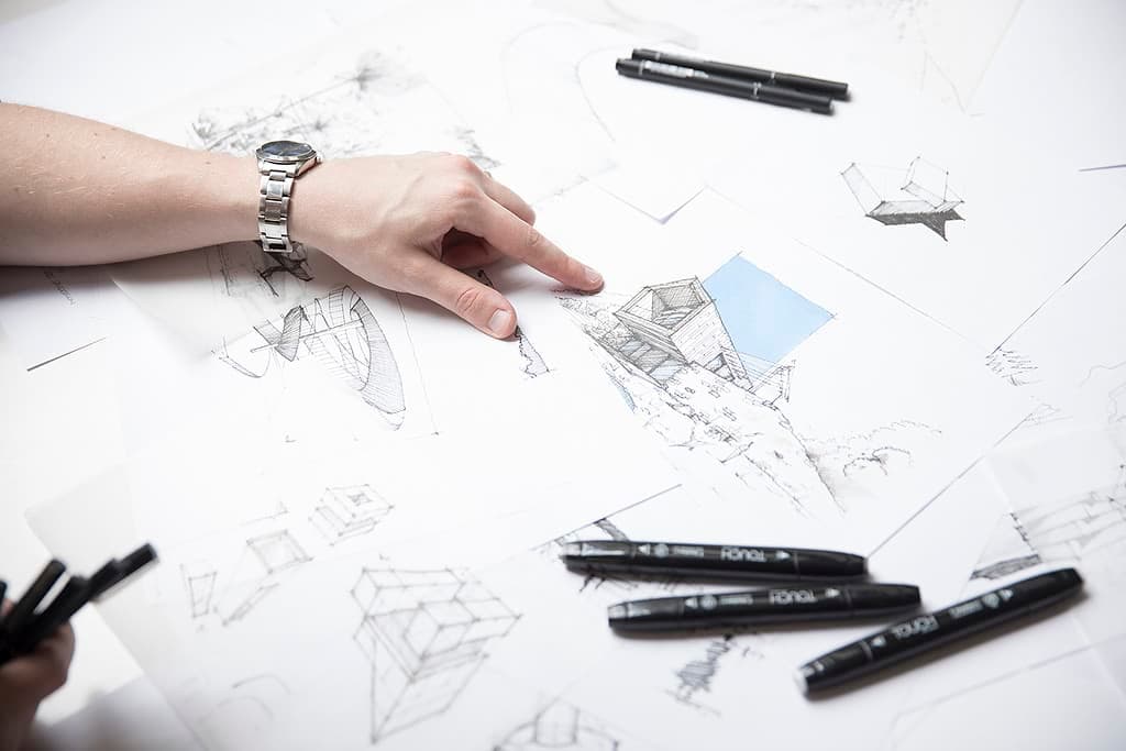 Architect hands sketching floor plan details with pen on trace paper