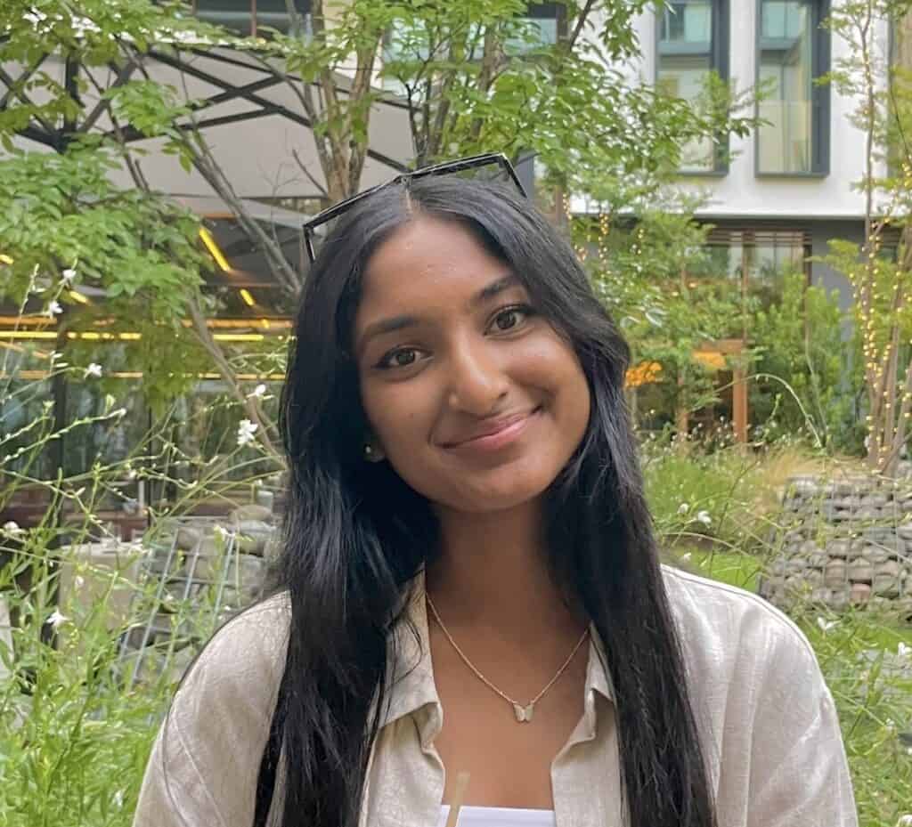 Professional headshot of smiling woman in a landscaped setting
