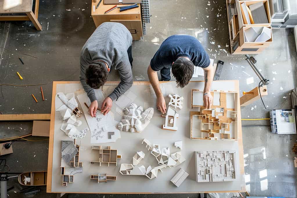 Architecture student in school workshop using hand tools to construct study model