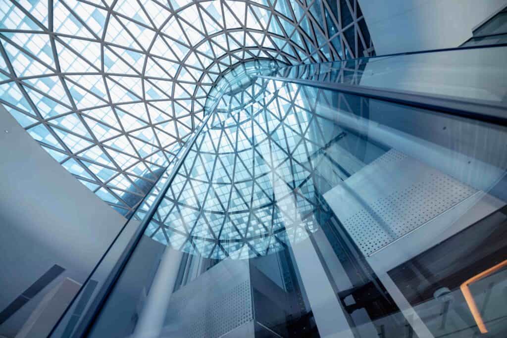 Contemporary glass atrium ceiling featuring intricate lattice framework and natural light