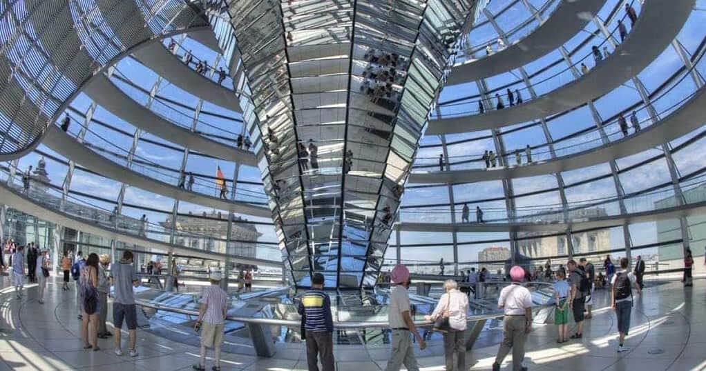 Visitors exploring inside the iconic glass dome of the Reichstag building in Berlin with panoramic city views